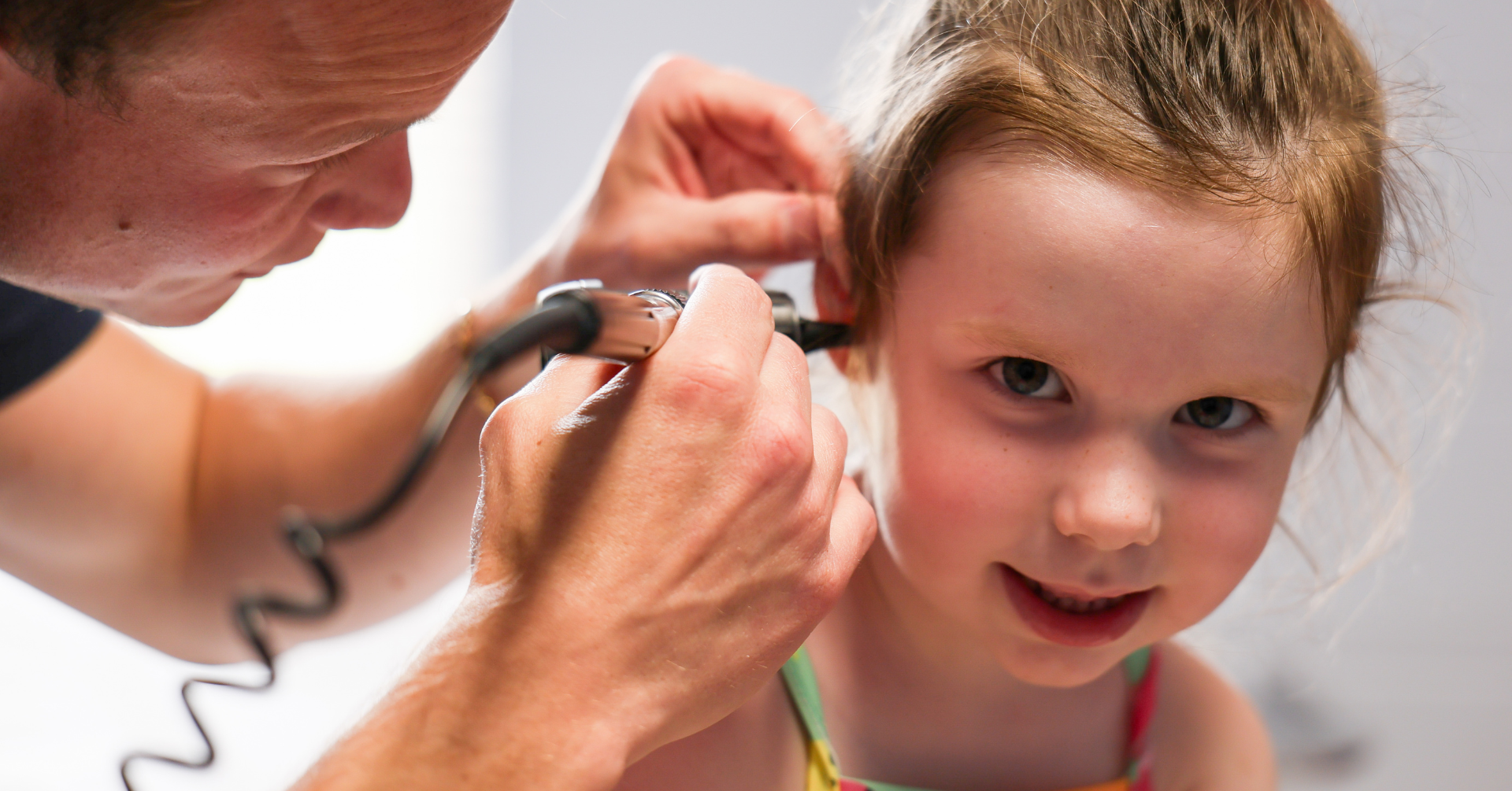 Doctor looking in kids ear